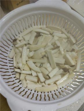 把过完热水的杏鲍菇捞出放在沥水筐内沥干水分