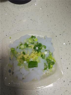 把切好的石花菜凉粉装入盘子内，放上葱末和蒜末，
