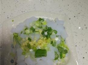 把切好的石花菜凉粉装入盘子内，放上葱末和蒜末，