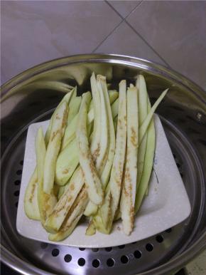 茄子清洗干净，去皮，切成粗细均匀的长条，装入盘内，冷水上锅，蒸十分钟左右
