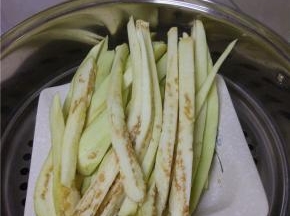 茄子清洗干净，去皮，切成粗细均匀的长条，装入盘内，冷水上锅，蒸十分钟左右
