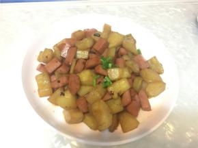 将黄瓜放入油锅中和火腿肠一起爆炒，然后加入一点水煮熟后加入盐味精和老干妈盛起。