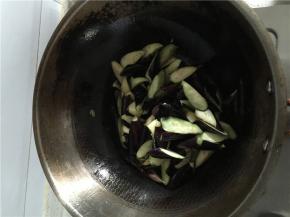 将锅中的油加热放入生姜和大蒜加入茄子爆炒。