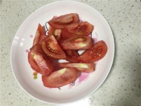 将番茄洗净后用热水浸泡3到5分钟，这样方便剥离番茄外皮，脱皮后口味更佳，切成小块。