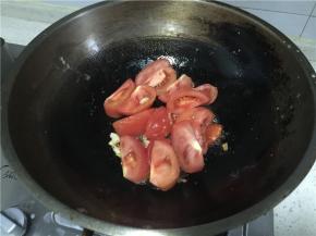 锅中留底油，加入姜蒜末，倒入番茄。