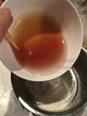 做月饼皮。转化糖浆、花生油、枧水倒入碗中搅拌均匀。