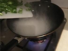 油下锅，油热后，先炒尖椒。（也可在热油中加入半颗大蒜，依据个人口味，不习惯吃蒜的人不加）
