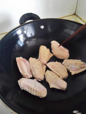 直接把鸡翅丢进锅里干炒，炒干水分