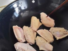 直接把鸡翅丢进锅里干炒，炒干水分