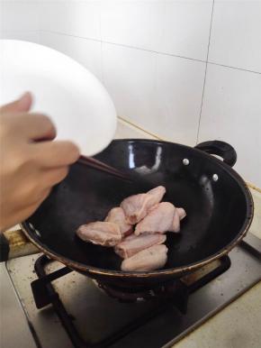 捞出鸡翅，锅里倒油再烧热，再倒入鸡翅，煎至表面金黄。