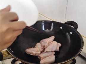 捞出鸡翅，锅里倒油再烧热，再倒入鸡翅，煎至表面金黄。