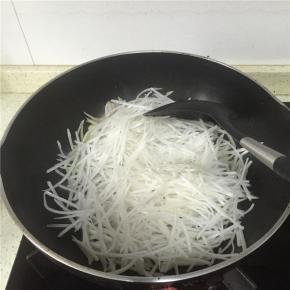 加入萝卜丝翻炒2分钟左右，加入少许料酒。
