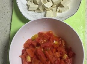 将西红柿剥皮，切碎（越碎越好），豆腐切拇指大小的丁。