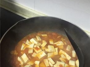 加入老豆腐、鲜酱油、少许盐翻炒入味。