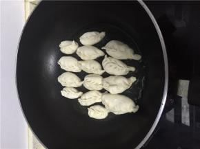 加入少量食用油，将饺子依次放入，煎至底部金黄。
