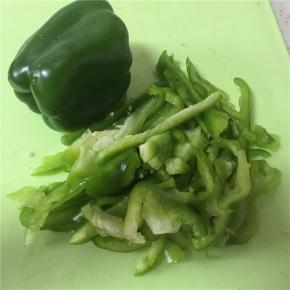 大青椒横向剖开，去除里面的芯后，切成丝。注意青椒的根蒂有大量农药残留，最好拿掉。