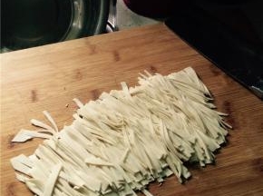 将面团擀开，用刀切丝。