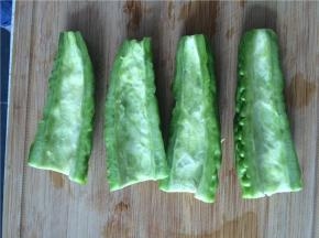 苦瓜纵面切成2半，用勺子将中间的瓤去掉，一定要将紧贴内层的白色膜尽量刮除干净（这个是带给你苦感的东西）。