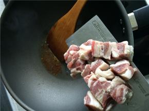 热锅凉油，放入冰糖，小火加热至冰糖完全融化并开始变黄时，下牛腩。