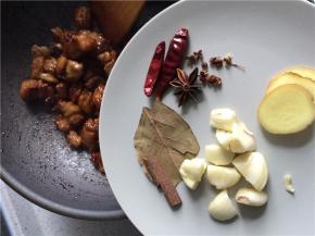 断翻炒至每块牛肉都裹上焦糖色，下切好的生姜、蒜瓣，以及干辣椒、香叶和桂皮。