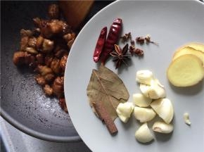 断翻炒至每块牛肉都裹上焦糖色，下切好的生姜、蒜瓣，以及干辣椒、香叶和桂皮。