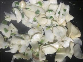 开中火翻炒，倒入盐继续翻炒几下后，将鸡腿菇倒入锅中