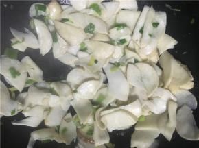 开中火翻炒，倒入盐继续翻炒几下后，将鸡腿菇倒入锅中