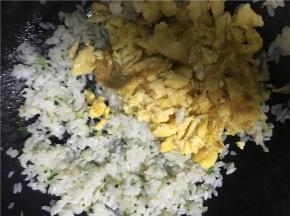 倒入炒好的鸡蛋，翻炒几下，待米饭和鸡蛋混合均匀后，关火出锅