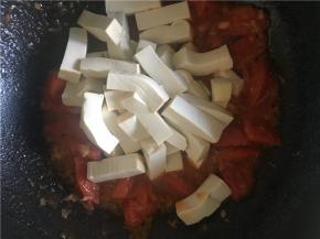待番茄炒至皮变卷，倒入豆腐继续翻炒