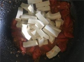 待番茄炒至皮变卷，倒入豆腐继续翻炒