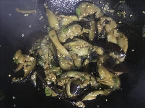 开大火翻炒，倒入盐、酱油继续翻炒几下后，将茄子倒入锅中