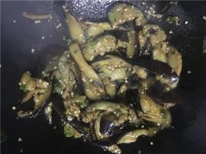 开大火翻炒，倒入盐、酱油继续翻炒几下后，将茄子倒入锅中