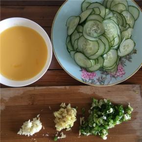 将黄瓜切片（厚度适中，不宜太薄或太厚），鸡蛋打入碗内并打撒（不要打出泡沫），佐料准备：姜切丝、蒜切末、葱切碎