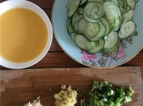 将黄瓜切片（厚度适中，不宜太薄或太厚），鸡蛋打入碗内并打撒（不要打出泡沫），佐料准备：姜切丝、蒜切末、葱切碎