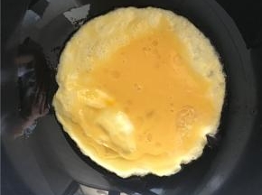 倒入打散的鸡蛋，不要急着翻炒待鸡蛋，先做成两面金黄的鸡蛋饼（刚开始先不急着炒碎鸡蛋而是做成鸡蛋饼，是因为蛋液由于空气被加热在鸡蛋饼内部形成气泡的作用，使鸡蛋内部结构比较疏松，可以达到外部金黄内部滑嫩的效果，吃起来也略有蓬松感）