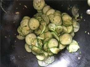 将火开至中火，加热几秒钟，倒入切好的黄瓜翻炒