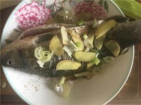 同样在鱼的两侧用葱姜蒜盖上，再撒上盐、花椒、酱油、料酒腌制10分钟