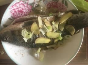 同样在鱼的两侧用葱姜蒜盖上，再撒上盐、花椒、酱油、料酒腌制10分钟