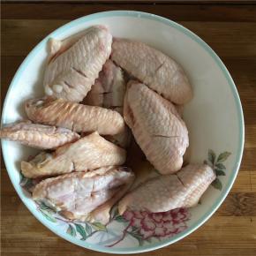 在处理好的鸡翅中倒入料酒和酱油腌制5分钟