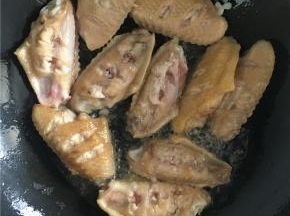用筷子将鸡翅放入锅中，煎至两面金黄