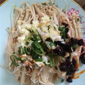 将烧熟的油泼到金针菇上的葱花等调料上