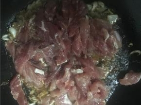 待油加热后，倒入葱花和蒜炒，再加入酱油、盐，炒一下倒入牛肉