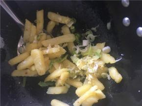 土豆煎熟，将多的油倒出到小碗里，再将葱姜蒜放入锅中