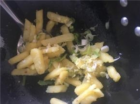 土豆煎熟，将多的油倒出到小碗里，再将葱姜蒜放入锅中
