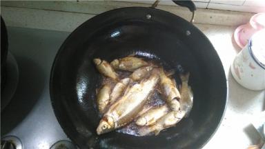倒入食用油，将小鲫鱼逐条放入油炸