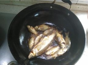 倒入食用油，将小鲫鱼逐条放入油炸