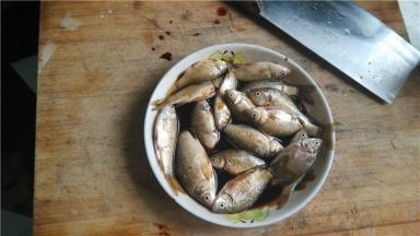 将小鲫鱼剖开，内脏掏出，去鱼鳞，用酱油腌制5分钟