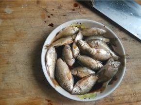 将小鲫鱼剖开，内脏掏出，去鱼鳞，用酱油腌制5分钟
