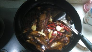 将所有的小鲫鱼放入锅中，倒入水、料酒、酱油、老姜、蒜、辣椒