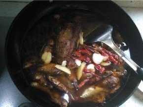 将所有的小鲫鱼放入锅中，倒入水、料酒、酱油、老姜、蒜、辣椒